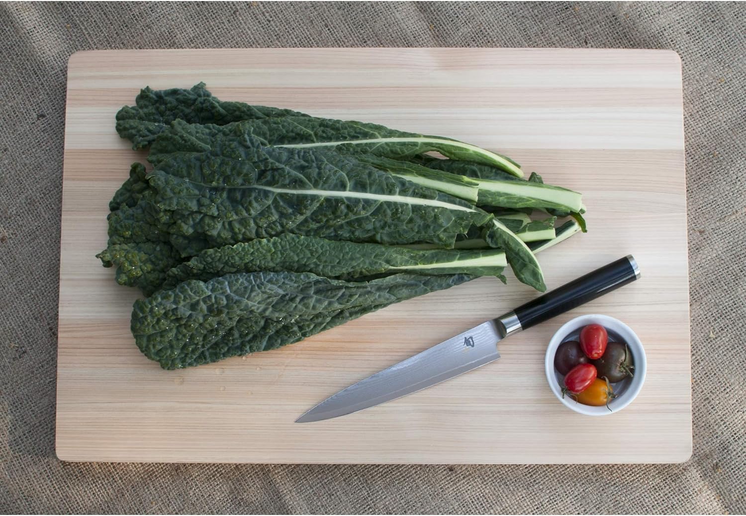 Shun Classic utility knife slicing produce on a cutting board