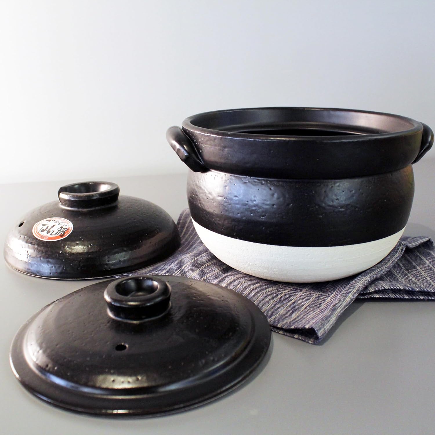 Banko donabe with its inner and outer lids laid out on a cloth