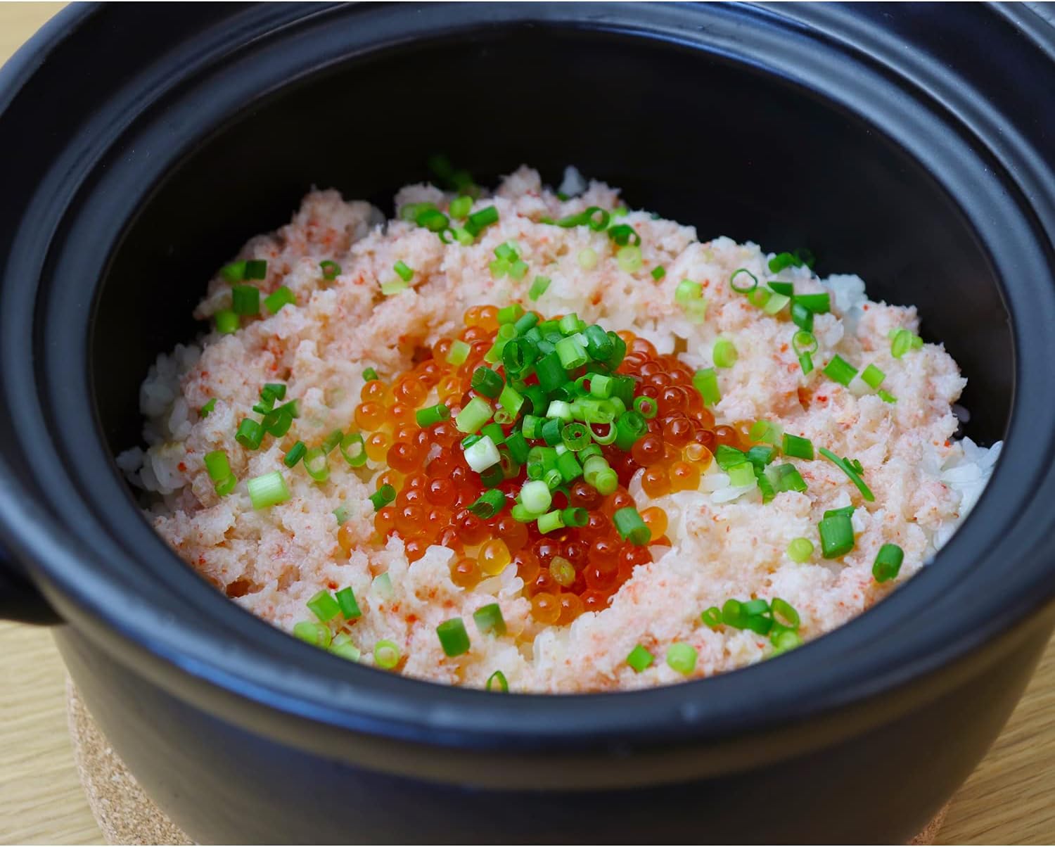 TOYO CASE donabe filled with cooked rice topped with salmon roe and green onion