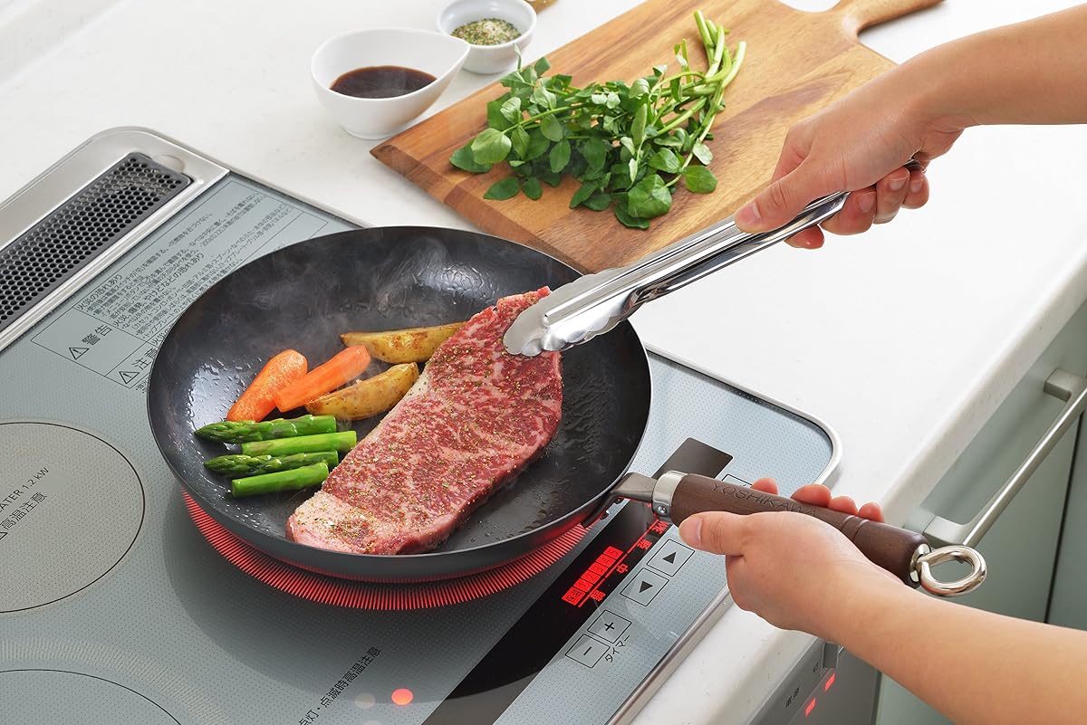 Steak, asparagus plus vegetables searing in the Yoshikawa steel pan on an induction cooktop