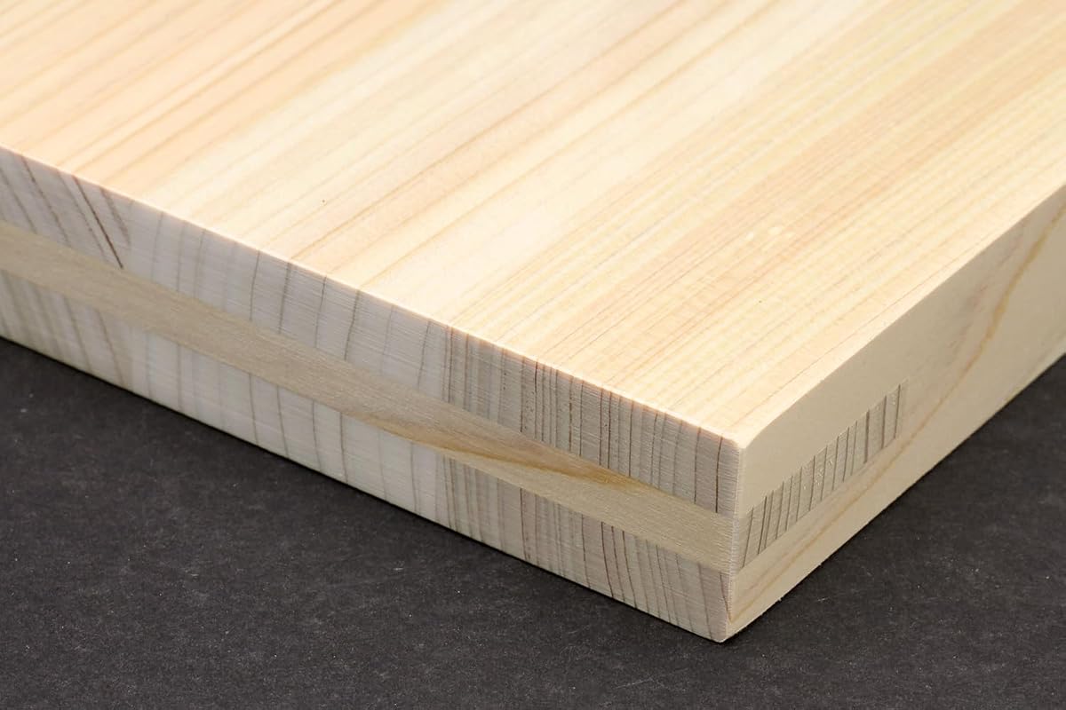 Close-up of the Yoshihiro board edge showing the pale maple anti-twist core running through the hinoki