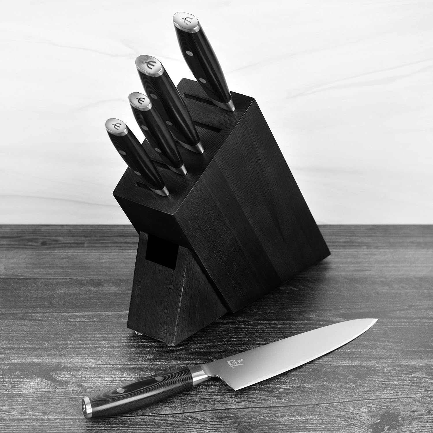 Yaxell Mon knife block on a wooden counter with a chef knife resting in front