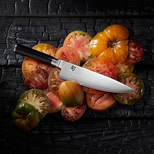 Shun Classic chef's knife resting on sliced heirloom tomatoes