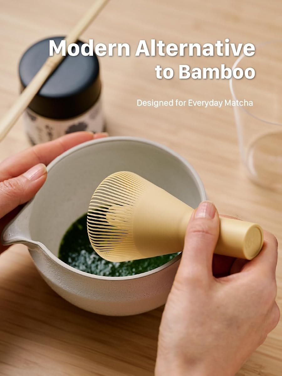 SUITENDO resin whisk being used to whisk matcha in a white spouted bowl