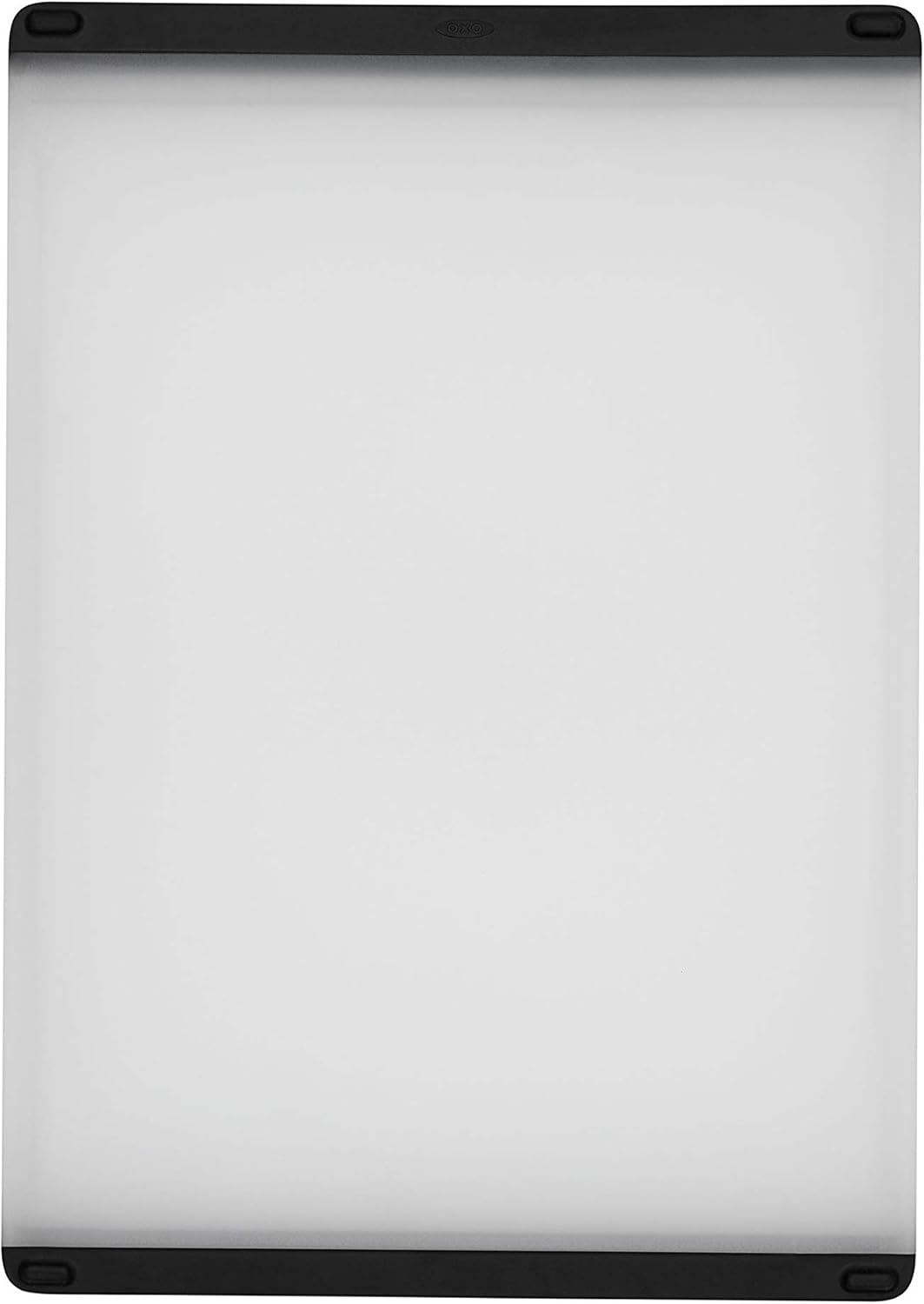 OXO Good Grips white plastic cutting board with black non-slip edges seen from above