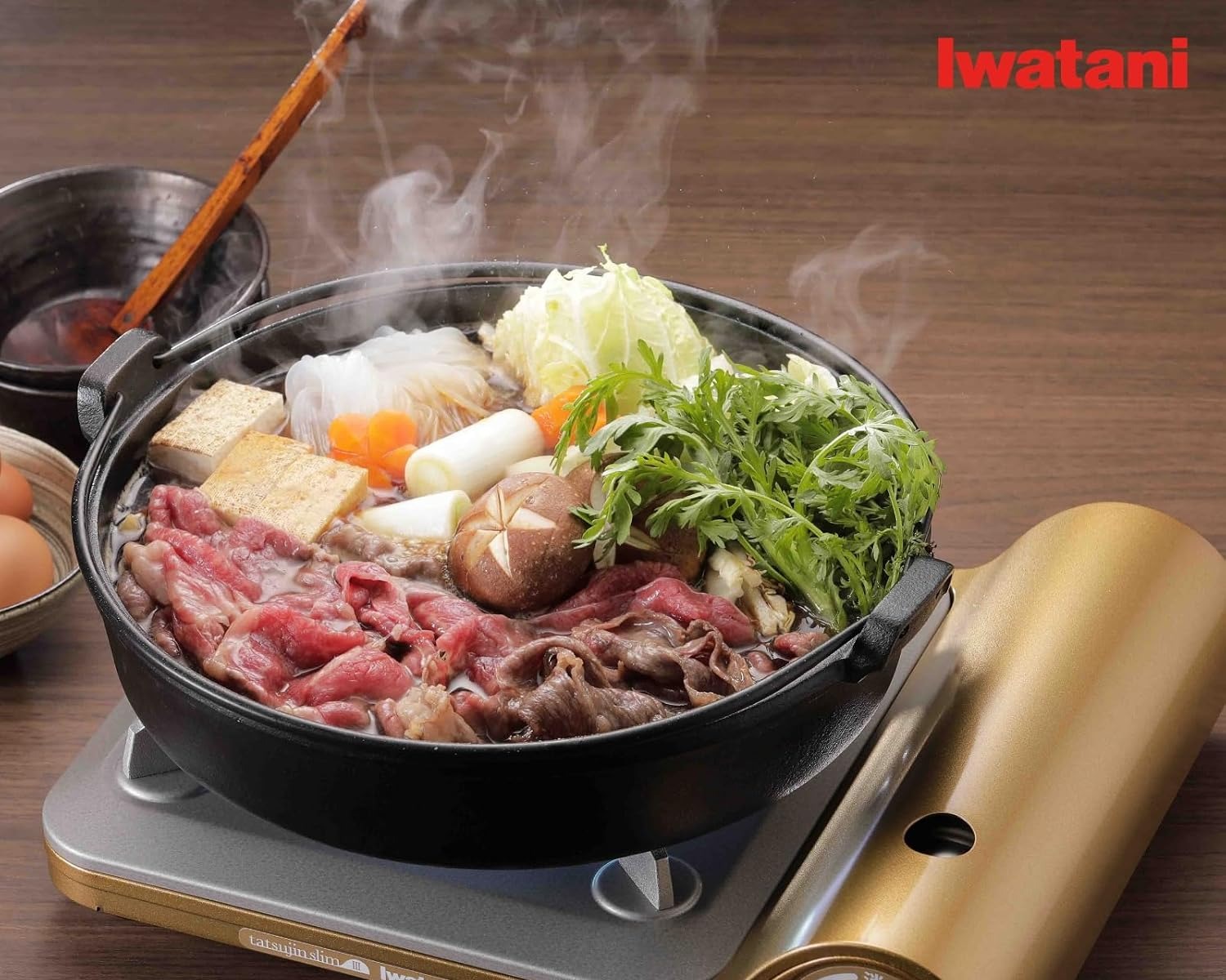 A sukiyaki pot of beef, tofu, mushrooms plus greens steaming on the gold Tatsujin Slim III at the table