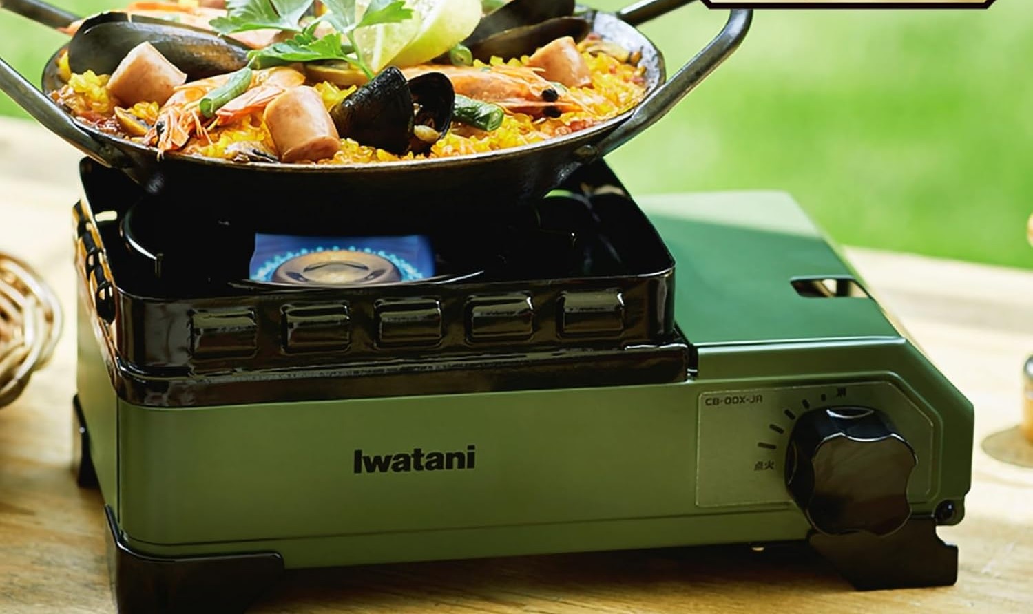 A wide pan of seafood and vegetables cooking on the olive Tough Maru Jr. on an outdoor table