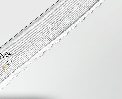 Close-up of the rippled Damascus pattern along the scalloped edge of the Seki Magoroku Damascus bread knife