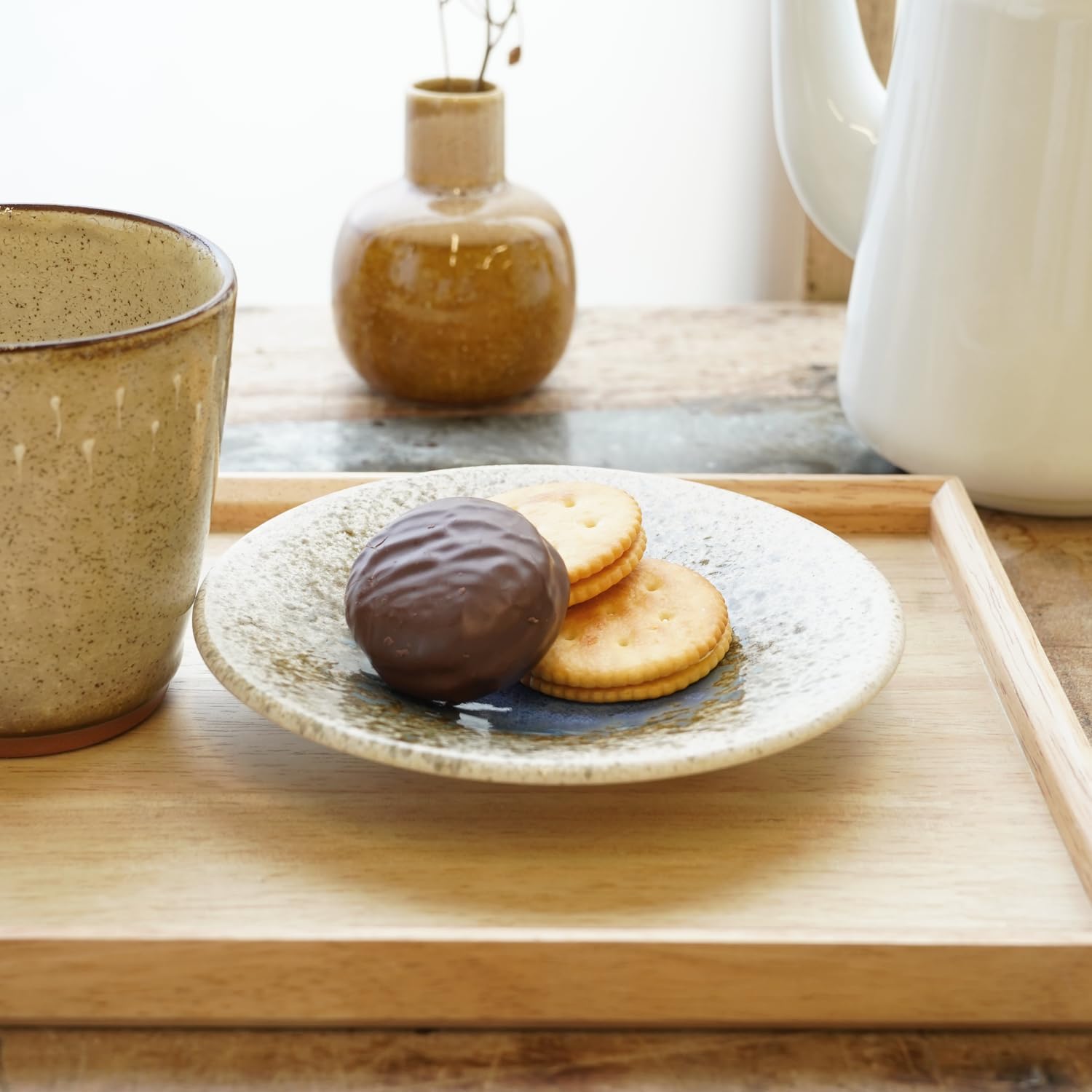 COTONOHA plate holding cookies on a wooden tray next to a cup
