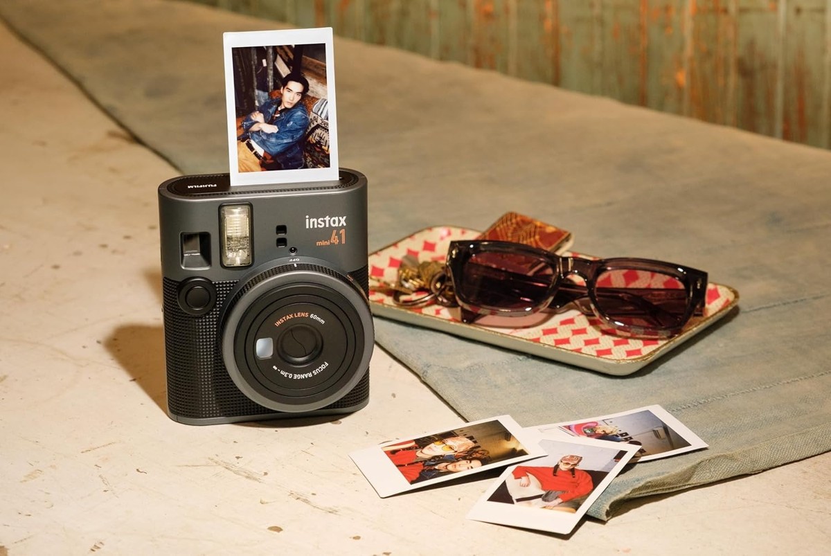 instax mini 41 on a wooden table with instant prints