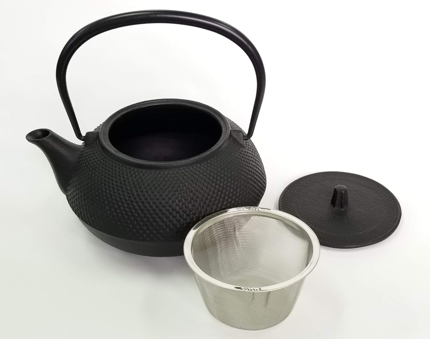 Iwachu tetsubin kettle with its lid off next to the included stainless steel strainer