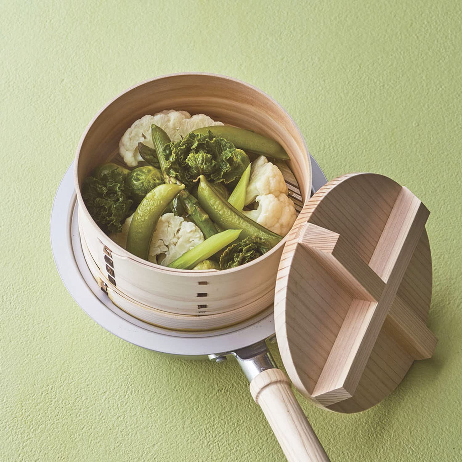 Nichinichi Dogu seiro set on a pan and filled with steamed cauliflower, snap peas and greens