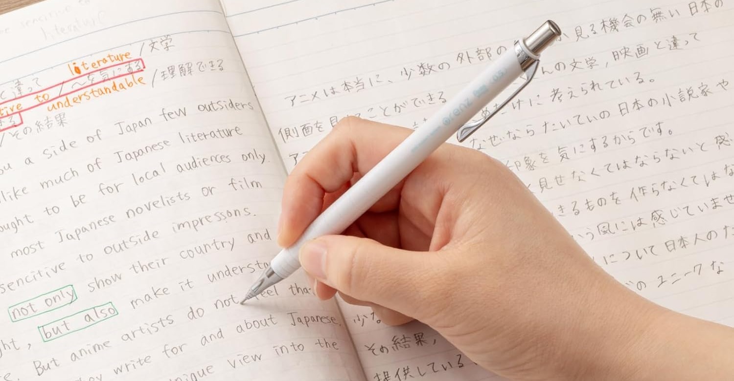 A hand writing notes in a ruled notebook with a white Pentel Orenz mechanical pencil
