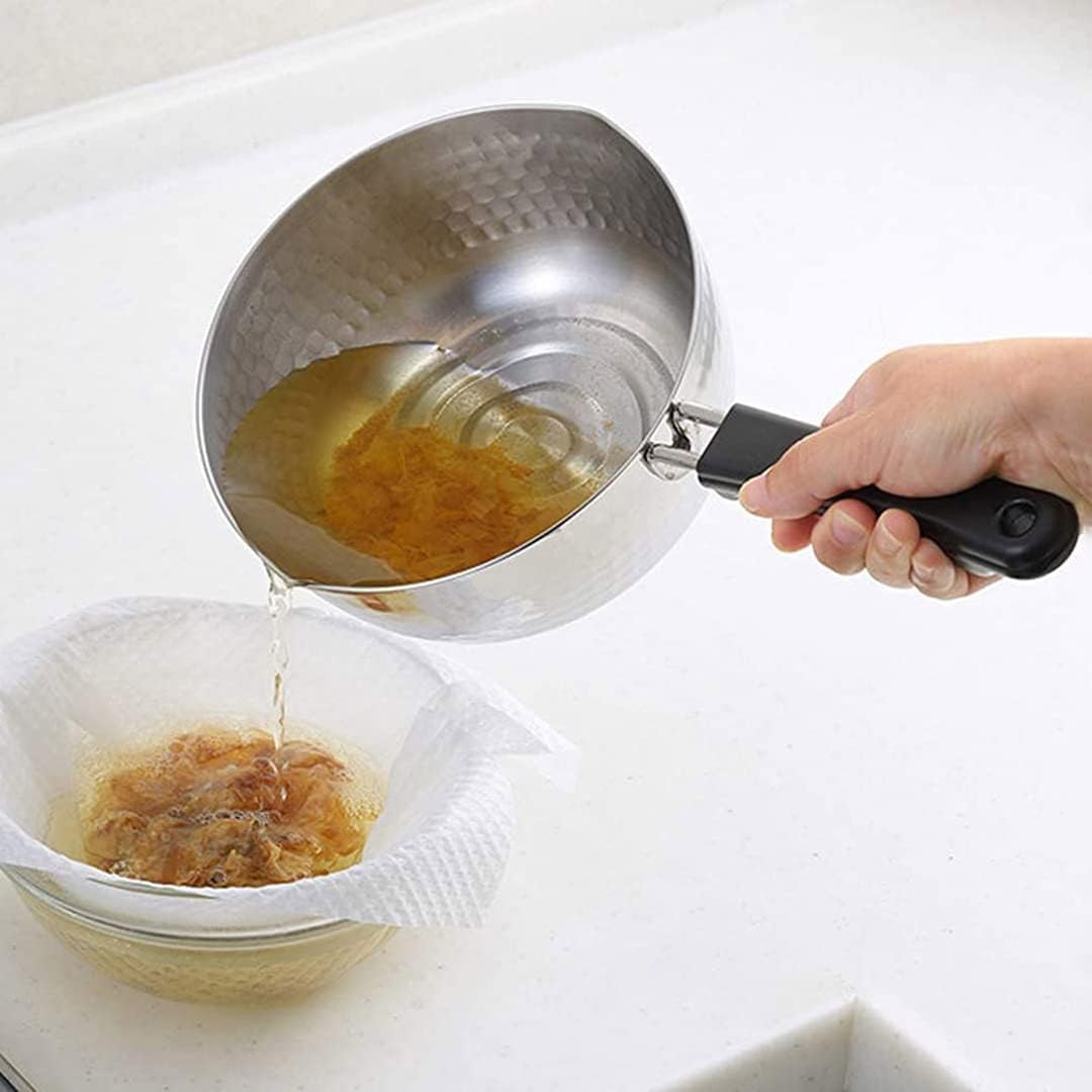 Pouring dashi from a TIKUSAN yukihira pot through a cloth-lined strainer