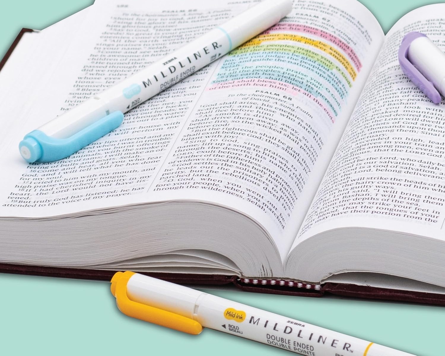 Zebra Mildliner pens resting on an open Bible with soft highlighted verses
